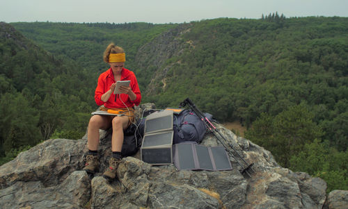 Man sitting on rock against mountains