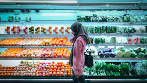 Rear view of woman standing in market stall