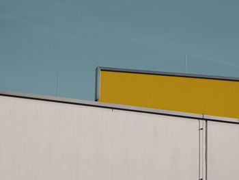 Low angle view of yellow wall against building