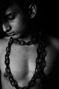 Close-up portrait of young woman against black background