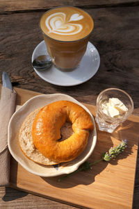 High angle view of bagel with cream cheese and cup of milk coffee. healthy food.