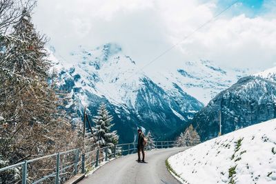 Rear view of person on snowcapped mountains against sky