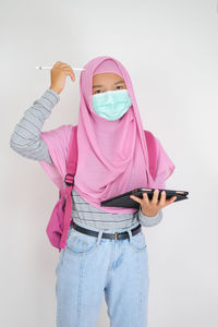 Low section of woman standing against pink background