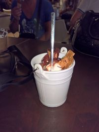 Close-up of hand holding ice cream on table