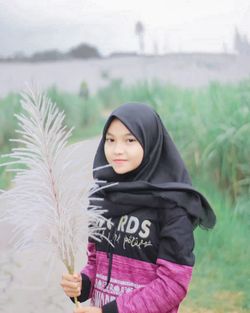 Portrait of smiling young woman standing outdoors