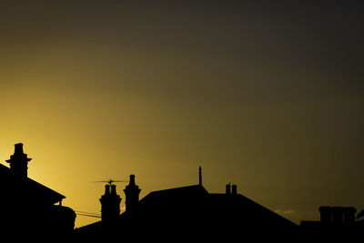 Low angle view of silhouette buildings against clear sky