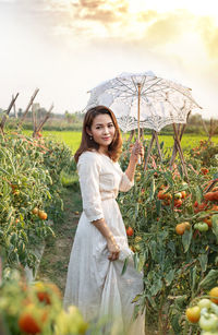 Portrait of a smiling young woman standing on field