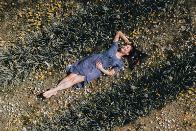 High angle view of woman lying down on field with flowers 