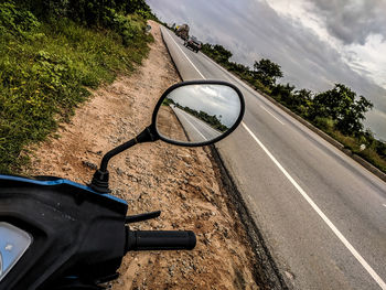 Side-view mirror of car on road