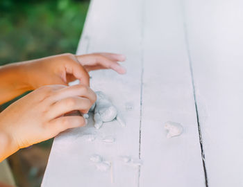 Kid hands in the process of creating the handicraft of polymer clay