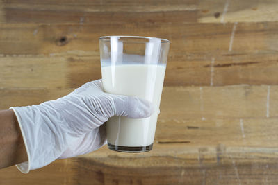 Midsection of man drinking glass on table