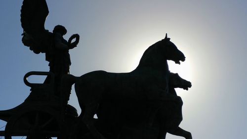 Low angle view of silhouette statue against clear sky