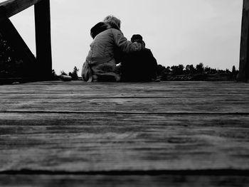 Rear view of couple sitting against sky