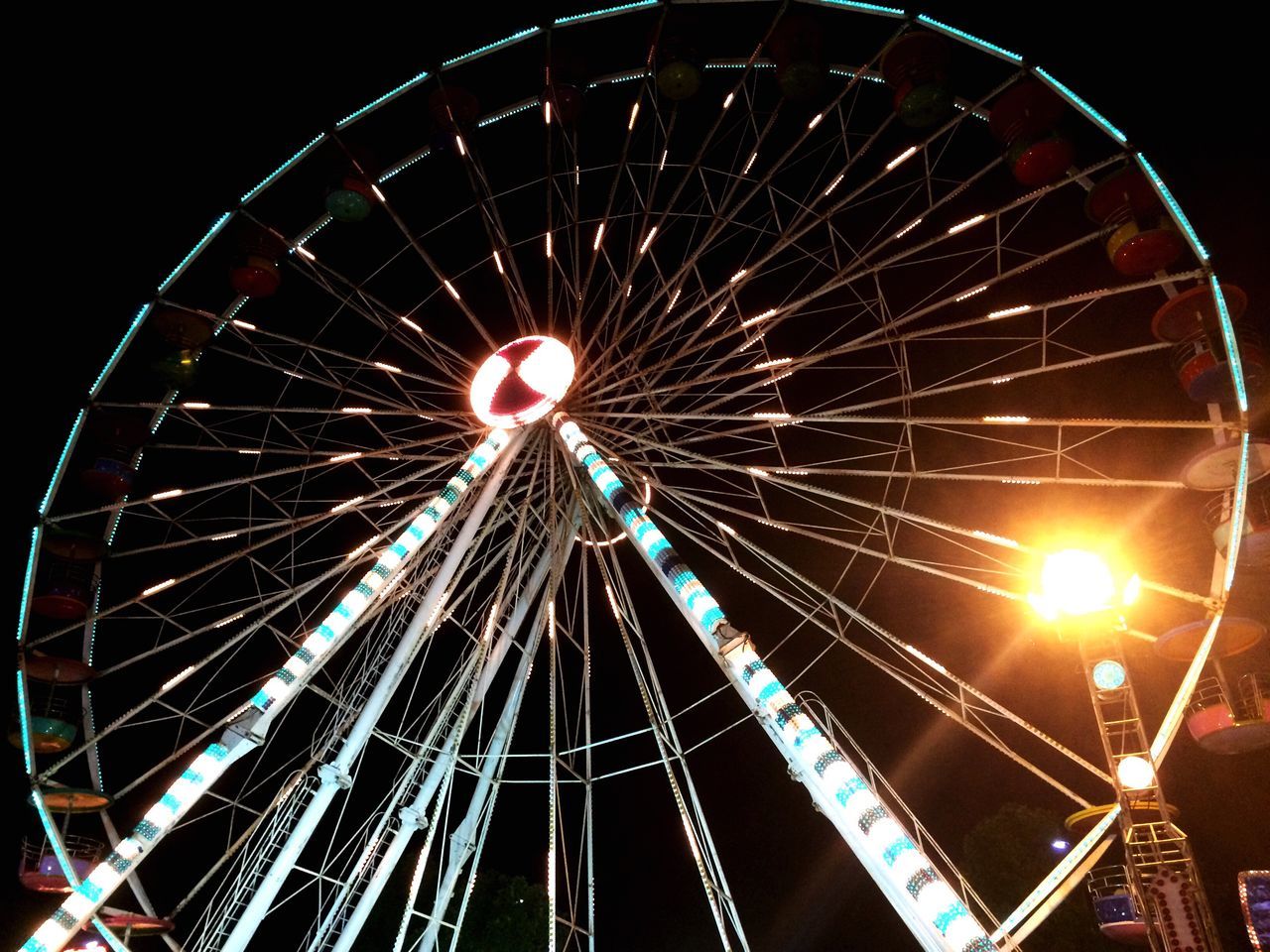 LOW ANGLE VIEW OF ILLUMINATED FERRIS WHEEL AGAINST SKY