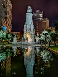 Reflection of buildings in lake at night