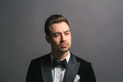 Portrait of young man against gray background