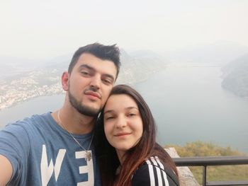 Portrait of smiling young couple against mountains