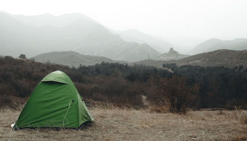 Tent on field by mountains against sky