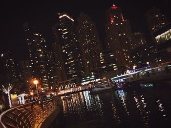Illuminated city against sky at night