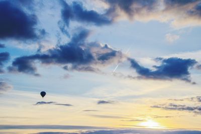 Hot air balloon flying against sky during sunset