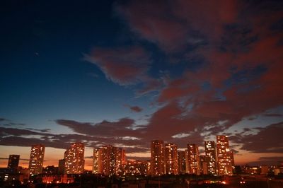 Illuminated cityscape against sky at night