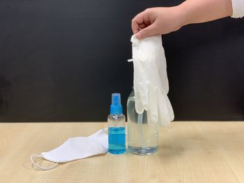 Person hand holding glass bottle on table