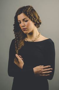 Portrait of a beautiful young woman over gray background