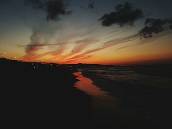 Scenic view of silhouette beach against sky during sunset