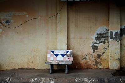 Empty chair against wall in old building