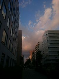 Low angle view of modern building against cloudy sky