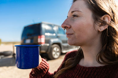 Close-up of woman holding coffee cup outdoors