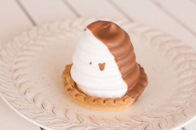 Two tone meringue pastry with a small chocolate drop.