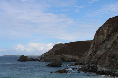 Rock formations by sea against sky