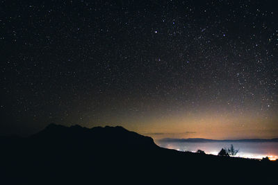 Scenic view of silhouette mountain against sky at night