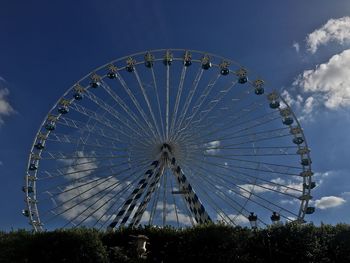 Low angle view of ferris wheel against blue sky