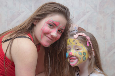 Side view of siblings with face paint against wall