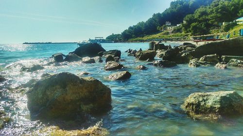 Scenic view of rocks in sea against sky