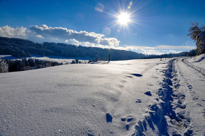 Scenic view of snow covered field against sky