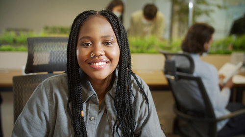 Portrait of smiling young woman sitting outdoors