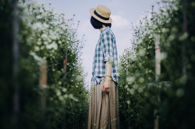 Side view of man standing by plants