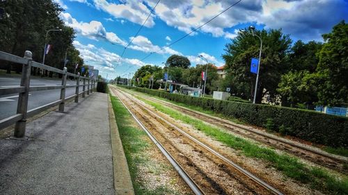 Railroad tracks amidst trees against sky