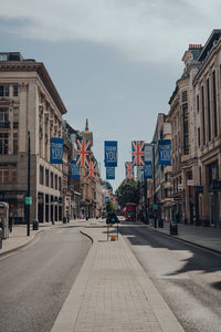 Road amidst buildings against sky in city