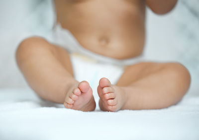 Close-up of baby boy lying on bed at home