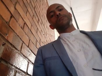 Low angle view of man standing against wall