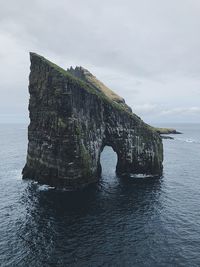 Rock formation in sea against sky