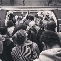 Rear view of people standing on railway station platform