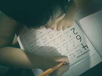 Child writing in book at home