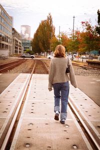 Rear view of woman walking on road