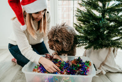 Midsection of young woman with christmas tree