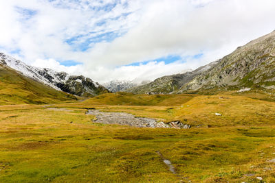 Scenic view of field and mountains against sky